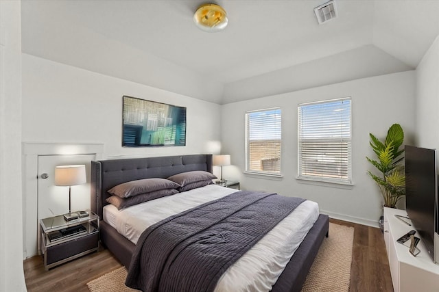 bedroom with dark hardwood / wood-style flooring and lofted ceiling