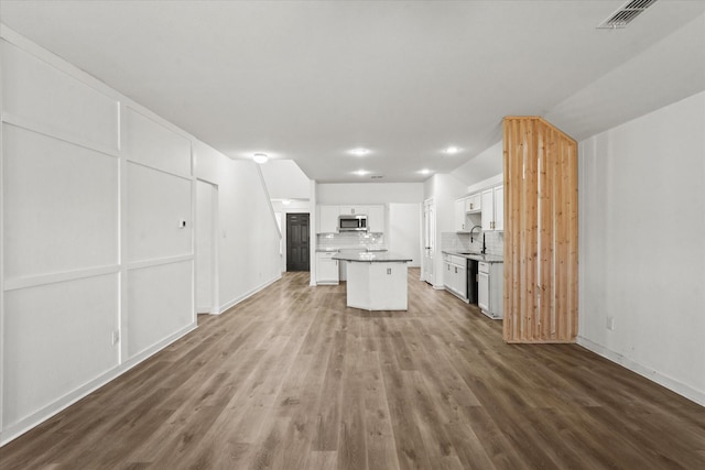 kitchen featuring sink, white cabinetry, a center island, black dishwasher, and backsplash