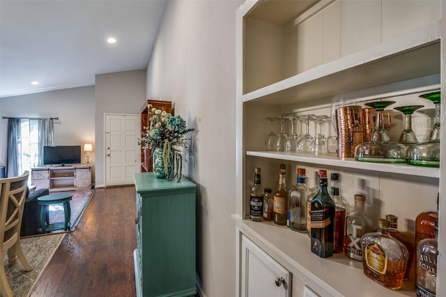 bar with lofted ceiling and dark hardwood / wood-style floors