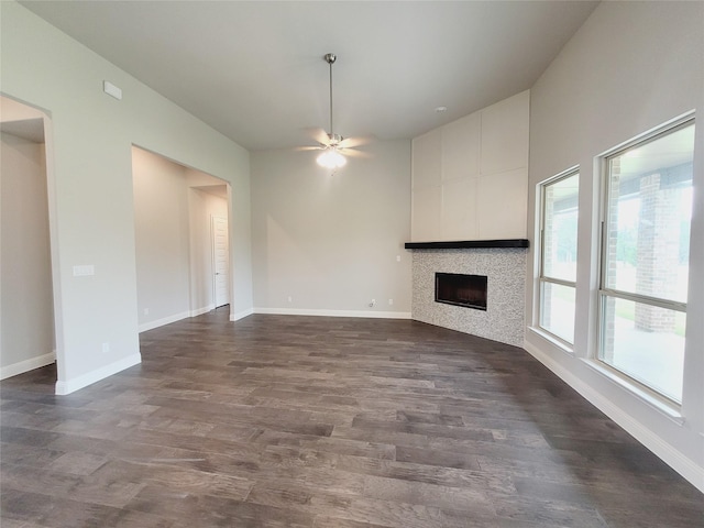 unfurnished living room featuring ceiling fan and dark hardwood / wood-style flooring