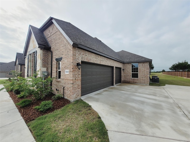 view of property exterior with a garage and central AC unit