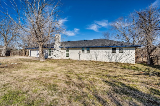 rear view of house with a garage and a yard