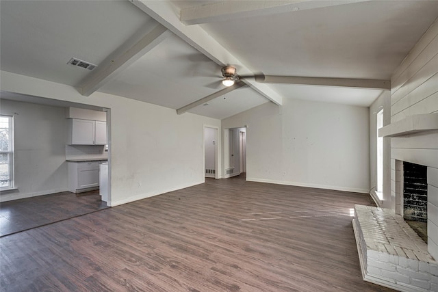 unfurnished living room featuring ceiling fan, a fireplace, dark hardwood / wood-style flooring, and lofted ceiling with beams