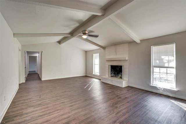 unfurnished living room featuring dark hardwood / wood-style flooring, a fireplace, a wealth of natural light, and vaulted ceiling with beams