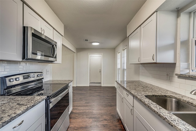 kitchen featuring white cabinetry, sink, dark hardwood / wood-style floors, and appliances with stainless steel finishes