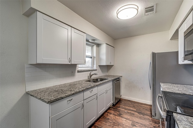 kitchen featuring white cabinetry, stainless steel appliances, sink, and tasteful backsplash