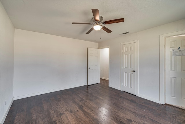 unfurnished bedroom featuring dark wood-type flooring, a textured ceiling, and ceiling fan