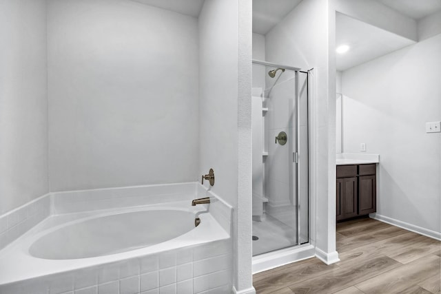 bathroom with wood-type flooring, plus walk in shower, and vanity