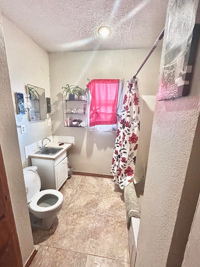 full bathroom with vanity, shower / bath combination with curtain, toilet, and a textured ceiling