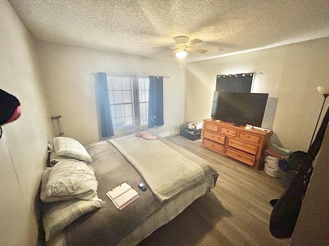 bedroom featuring a textured ceiling, wood-type flooring, and ceiling fan