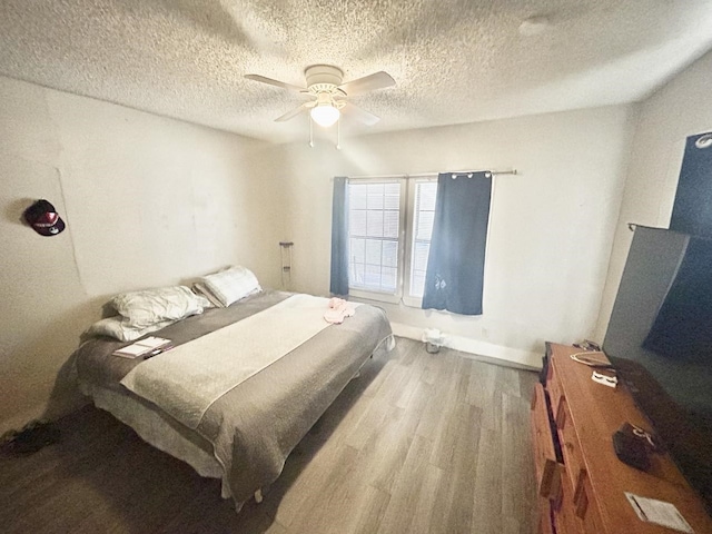 bedroom featuring hardwood / wood-style floors, a textured ceiling, and ceiling fan