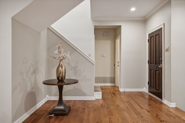 entrance foyer with wood-type flooring and ornamental molding