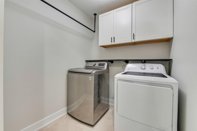 washroom with washing machine and dryer and cabinets