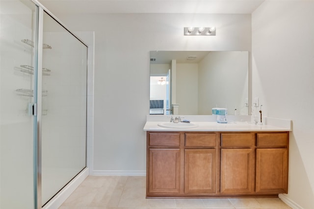 bathroom with tile patterned flooring, vanity, and walk in shower