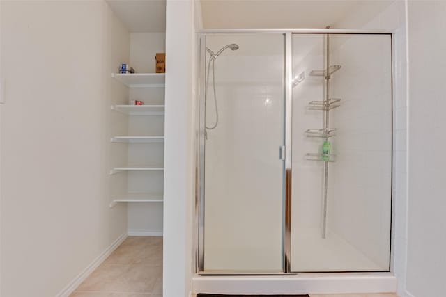 bathroom with an enclosed shower and tile patterned flooring