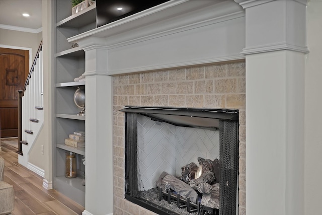 details with crown molding, a fireplace, and hardwood / wood-style floors