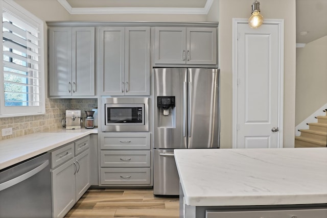 kitchen with appliances with stainless steel finishes, decorative light fixtures, and gray cabinetry