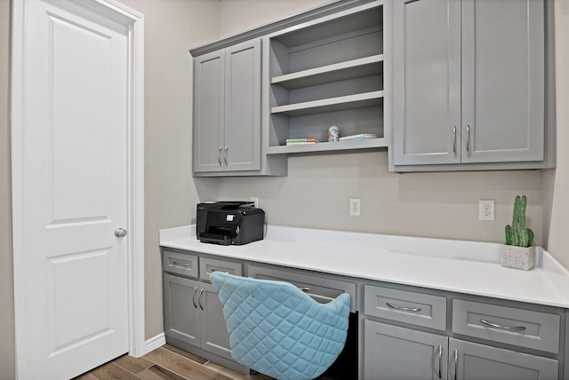 office area with built in desk and dark wood-type flooring