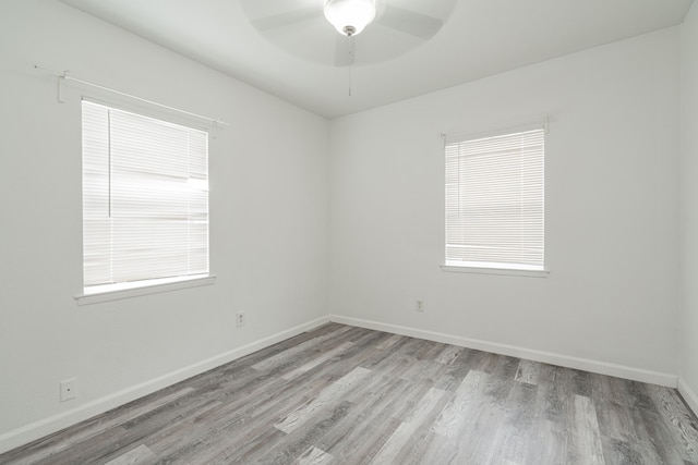 empty room featuring plenty of natural light, ceiling fan, and light hardwood / wood-style floors