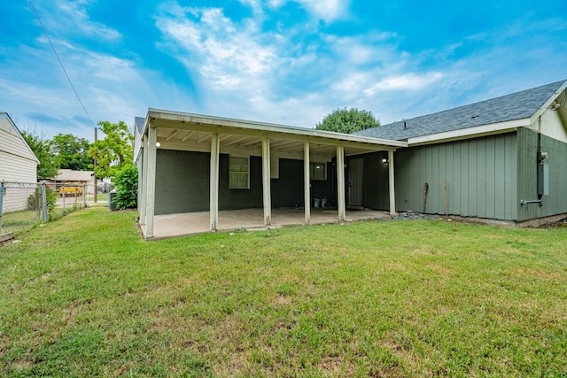 back of property with a patio area and a lawn