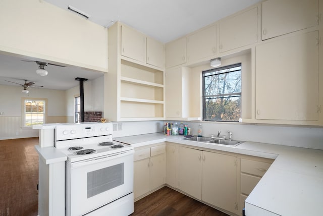 kitchen featuring sink, white electric range oven, cream cabinets, dark hardwood / wood-style flooring, and kitchen peninsula