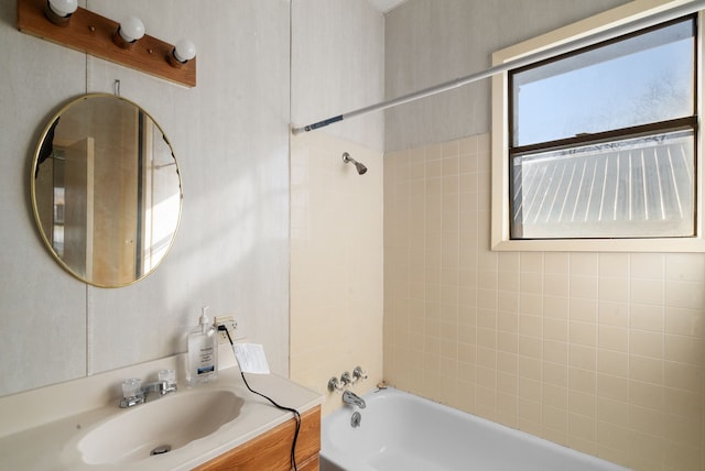 bathroom with tiled shower / bath combo and vanity