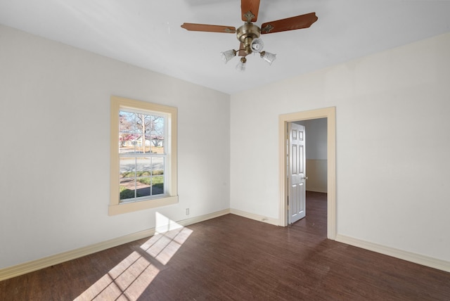 spare room with dark wood-type flooring and ceiling fan