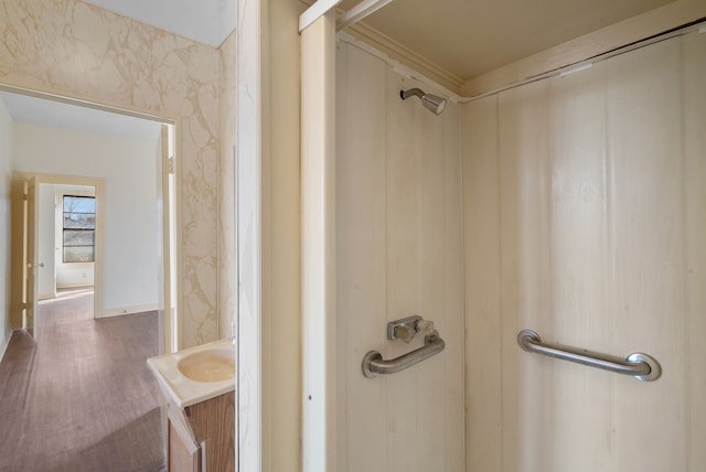 bathroom featuring crown molding, vanity, wood-type flooring, and a shower