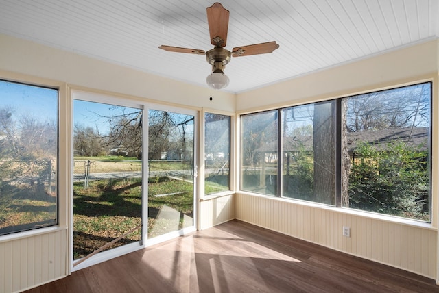 unfurnished sunroom featuring ceiling fan, wood ceiling, and a healthy amount of sunlight