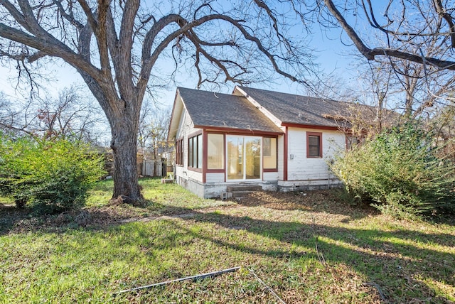 rear view of property featuring a yard