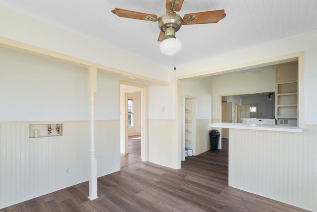 empty room with ceiling fan, built in features, and dark hardwood / wood-style flooring