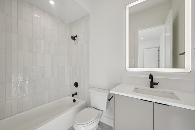 full bathroom featuring tiled shower / bath, vanity, and toilet