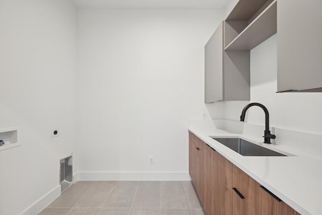 washroom with sink, cabinets, light tile patterned floors, hookup for a washing machine, and electric dryer hookup