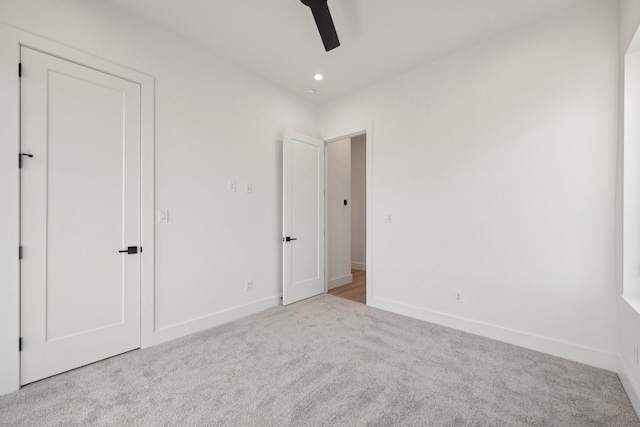 unfurnished bedroom featuring light carpet and ceiling fan