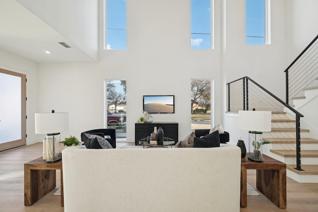 living room featuring light hardwood / wood-style floors and a high ceiling