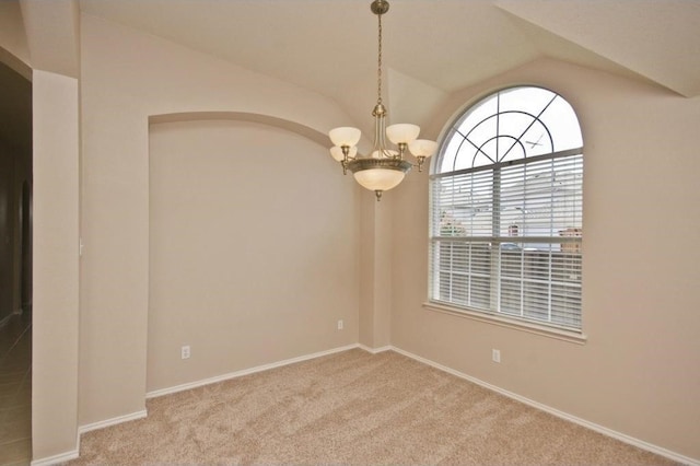 unfurnished room with vaulted ceiling, light carpet, and a notable chandelier