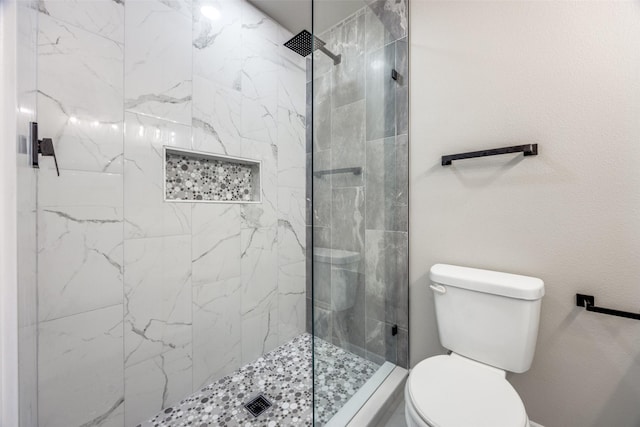 bathroom featuring tiled shower and toilet