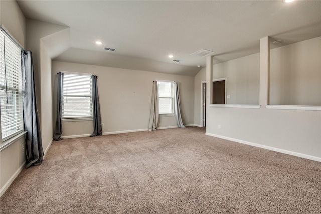 carpeted spare room with vaulted ceiling and a healthy amount of sunlight