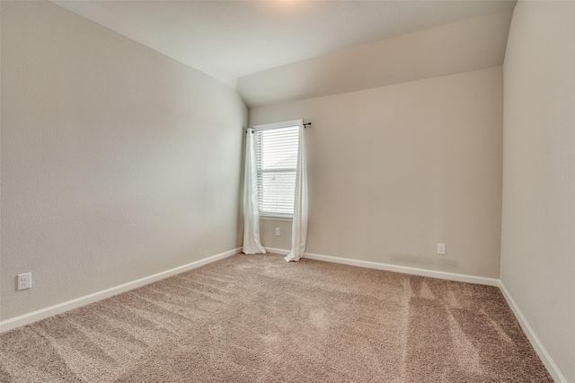 carpeted spare room with lofted ceiling