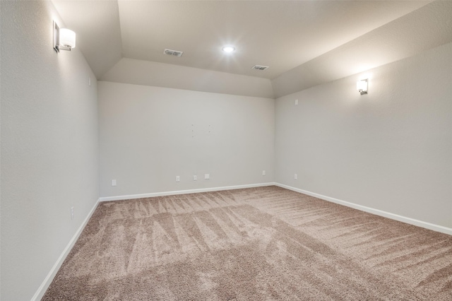 spare room featuring lofted ceiling and carpet