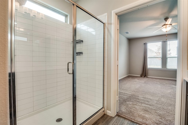 bathroom featuring ceiling fan and a shower with shower door