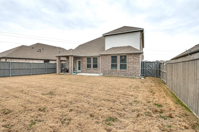 rear view of house with a patio and a lawn