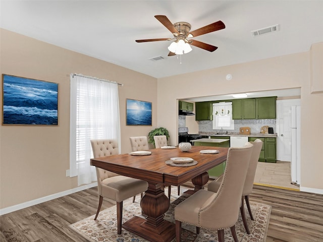 dining area with hardwood / wood-style flooring, ceiling fan, plenty of natural light, and sink