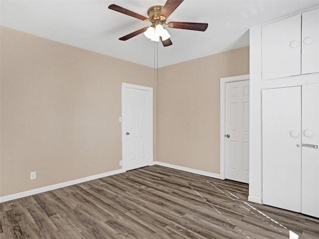 unfurnished bedroom featuring dark wood-type flooring and ceiling fan