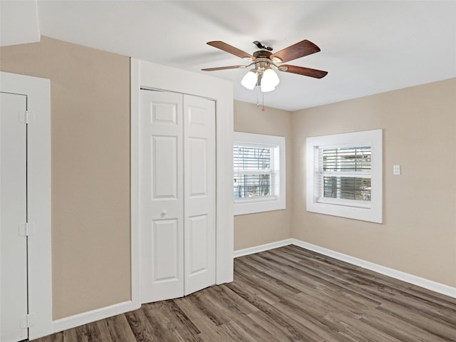 unfurnished bedroom featuring hardwood / wood-style flooring, a closet, and ceiling fan