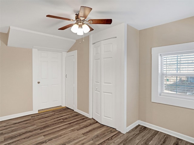 unfurnished bedroom featuring dark wood-type flooring, ceiling fan, and lofted ceiling