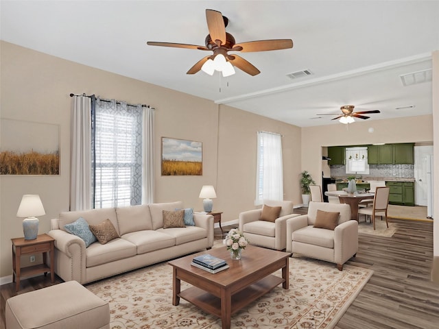 living room with wood-type flooring, plenty of natural light, and ceiling fan