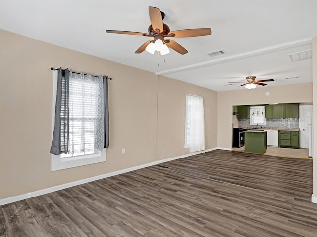 unfurnished living room featuring dark hardwood / wood-style floors, sink, and ceiling fan