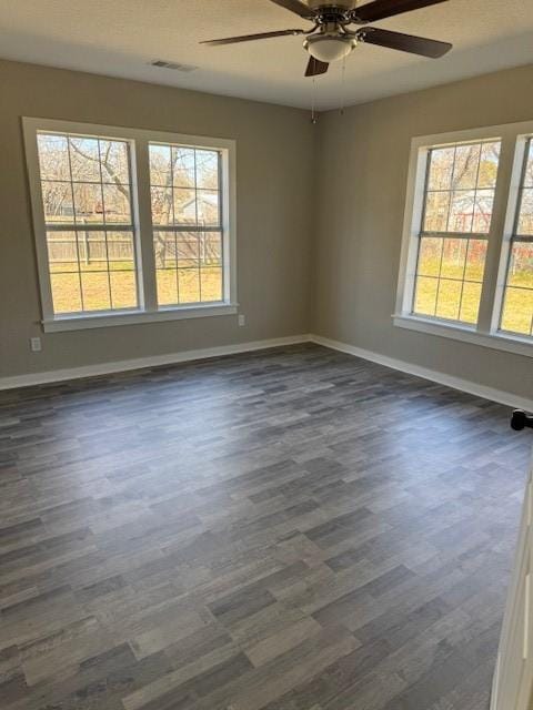 empty room with dark wood-type flooring and ceiling fan