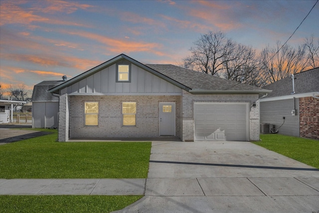 view of front facade featuring cooling unit, a garage, and a yard